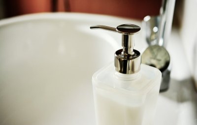 Seifespender, angeschnitten mit Waschbecken im Hintergrund